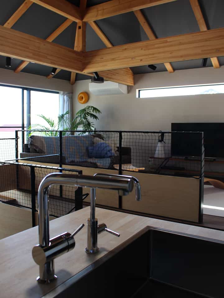 Bright living and kitchen space with natural wood tones and a protective safety net