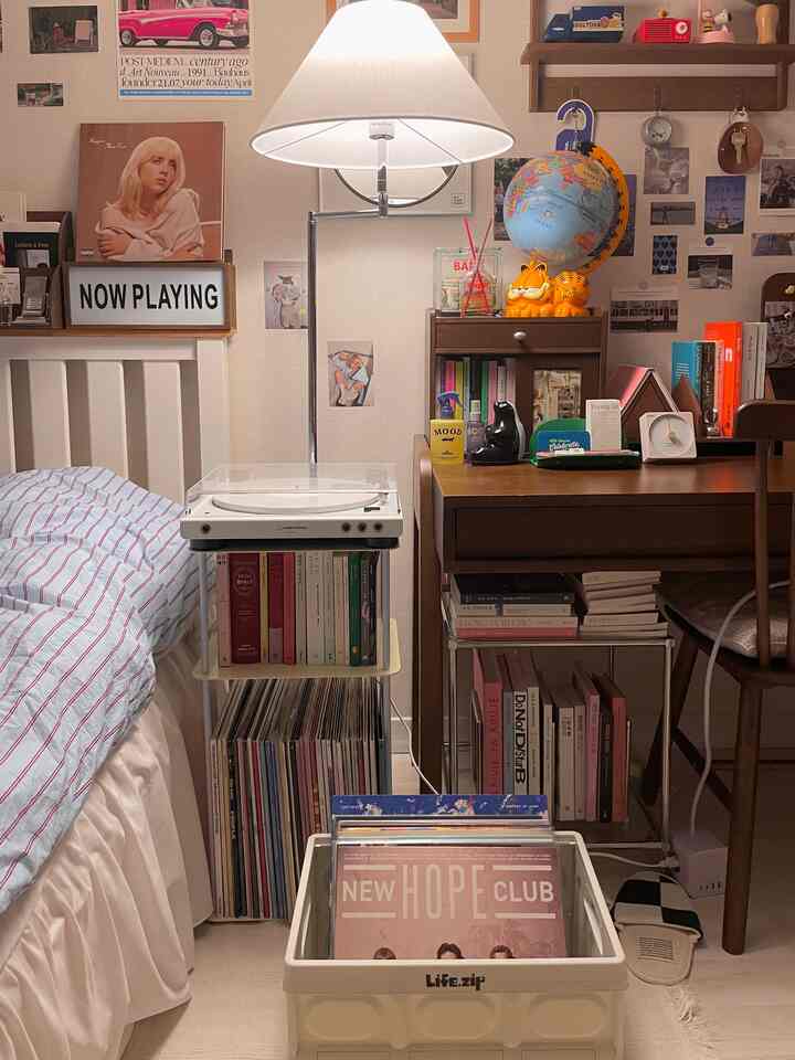 White and natural toned bedroom featuring an LP turntable, desk, and various cozy interior decor items