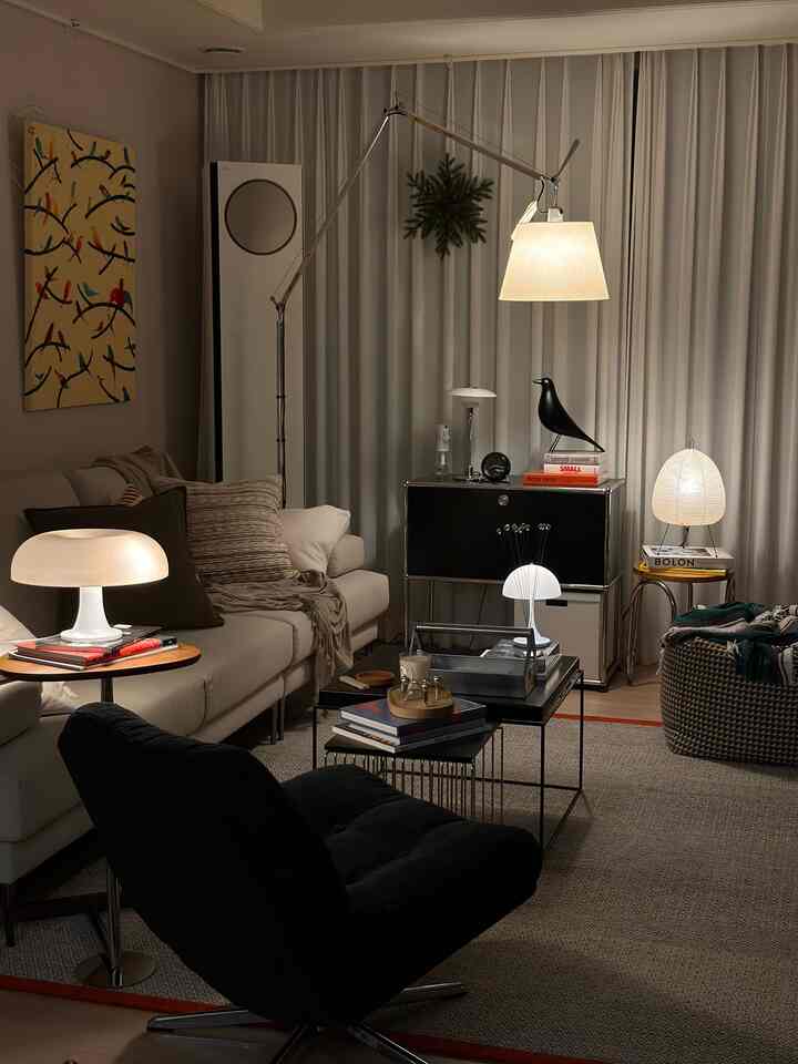 Warm white and black toned living room featuring modern sofa and various lamps creating a cozy atmosphere