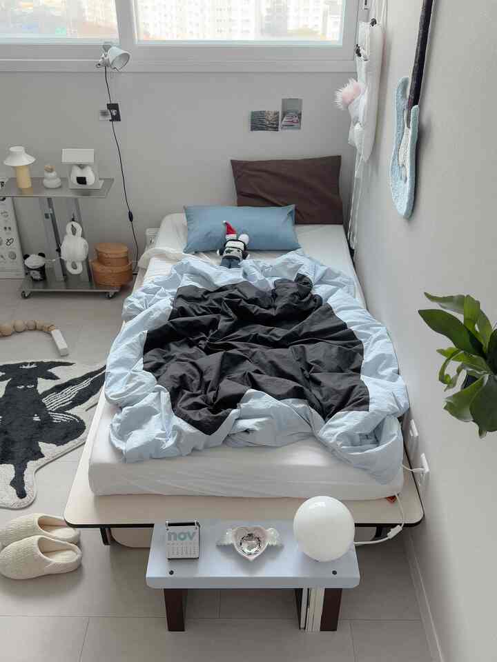 Light gray and white toned bedroom featuring a simple bed and cozy decor in a modern setting