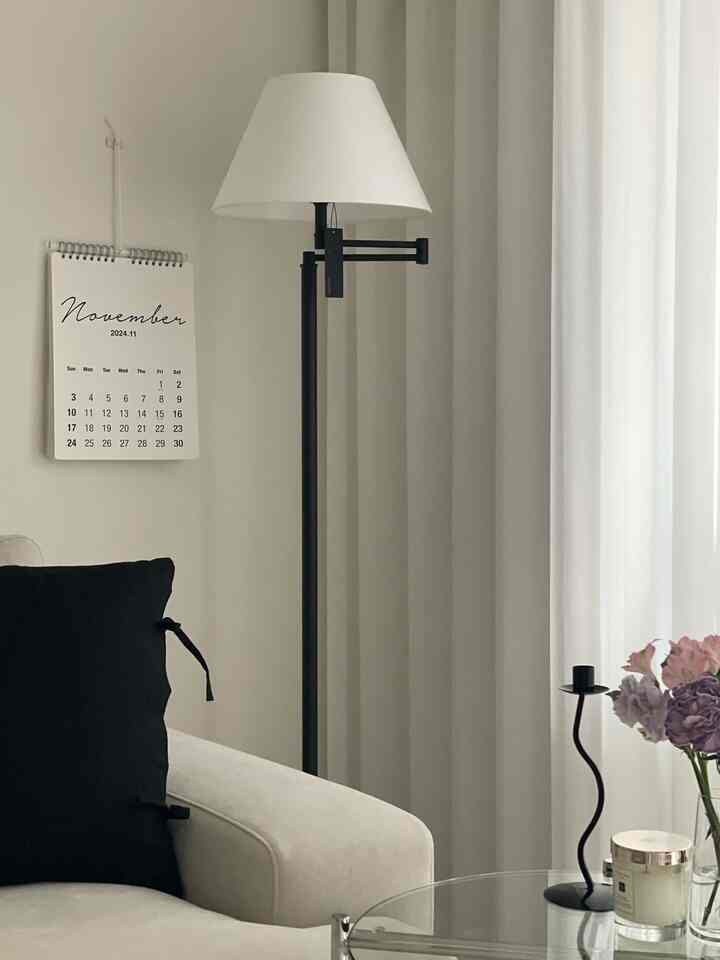 Beige and black toned living room featuring sofa and floor lamp with minimal and calm atmosphere