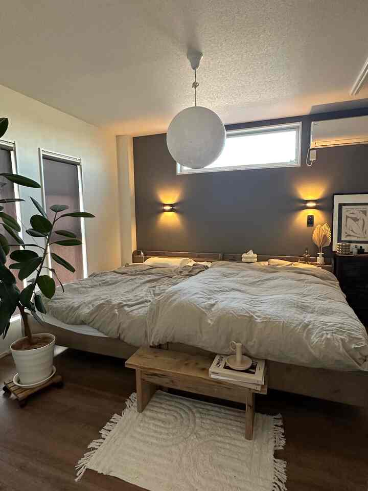 Natural brown and white toned bedroom featuring two double beds placed side by side, creating a cozy family space.