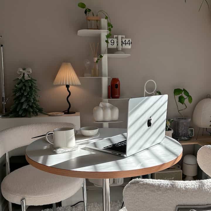 ベージュの壁とホワイトのダイニングテーブル、ブークレチェアが配置されたナチュラルモダンなおうちカフェ空間