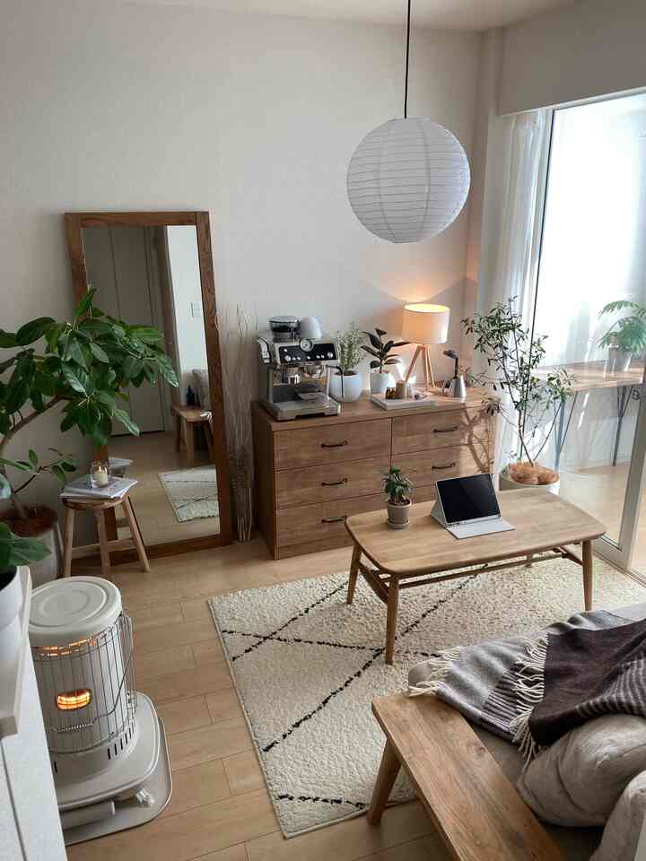 ナチュラルな色調のリビング、木製のローテーブルと収納チェストが配置された温かみのある空間