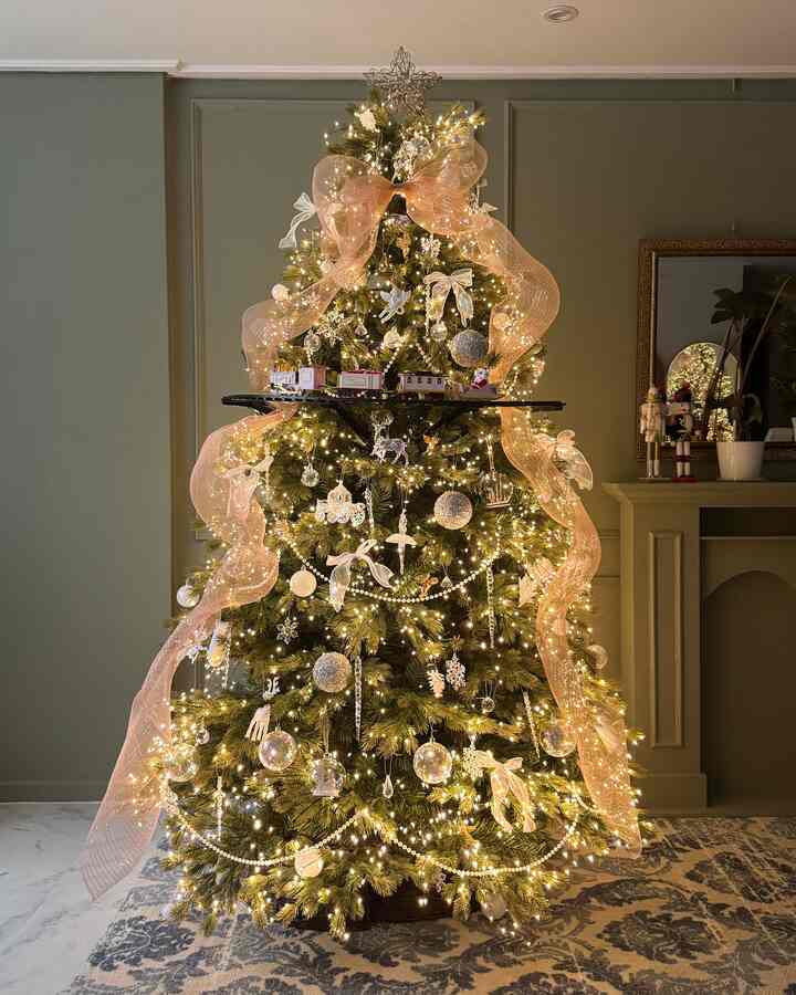 ゴールドの光とリボンで飾られたクリスマスツリーが配置された、温かみのあるリビングルームの雰囲気のあるインテリア