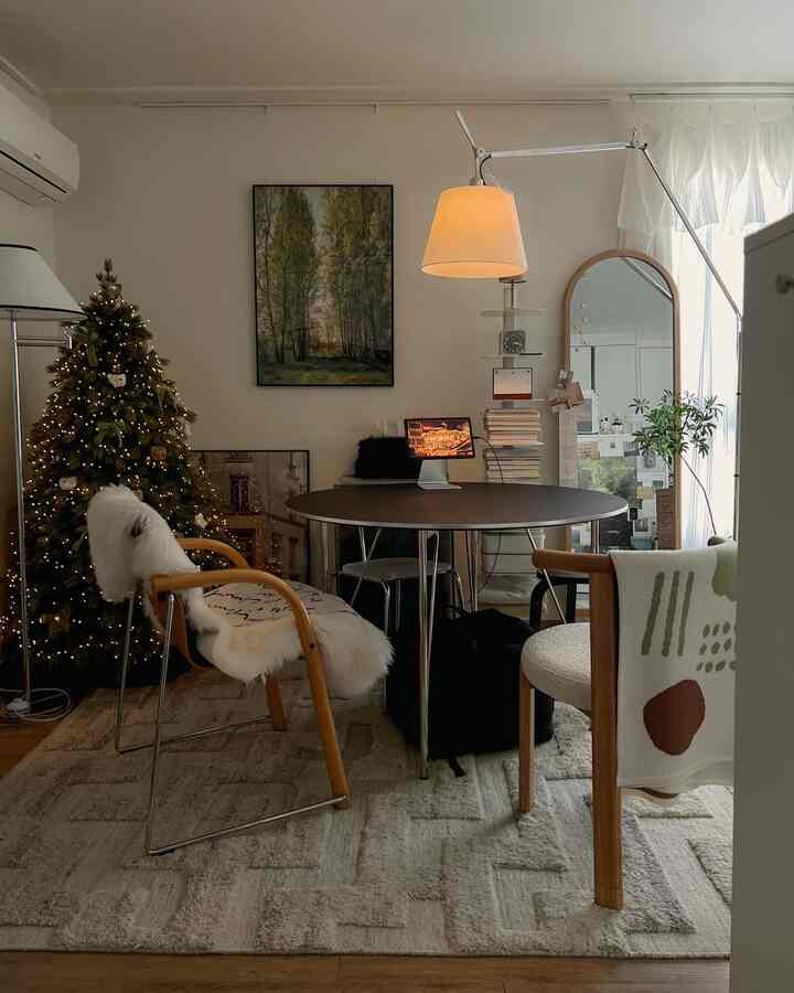 ナチュラルな木目調とブラックテーブル、クリスマスツリーがある8畳ワンルームのリビングスペース