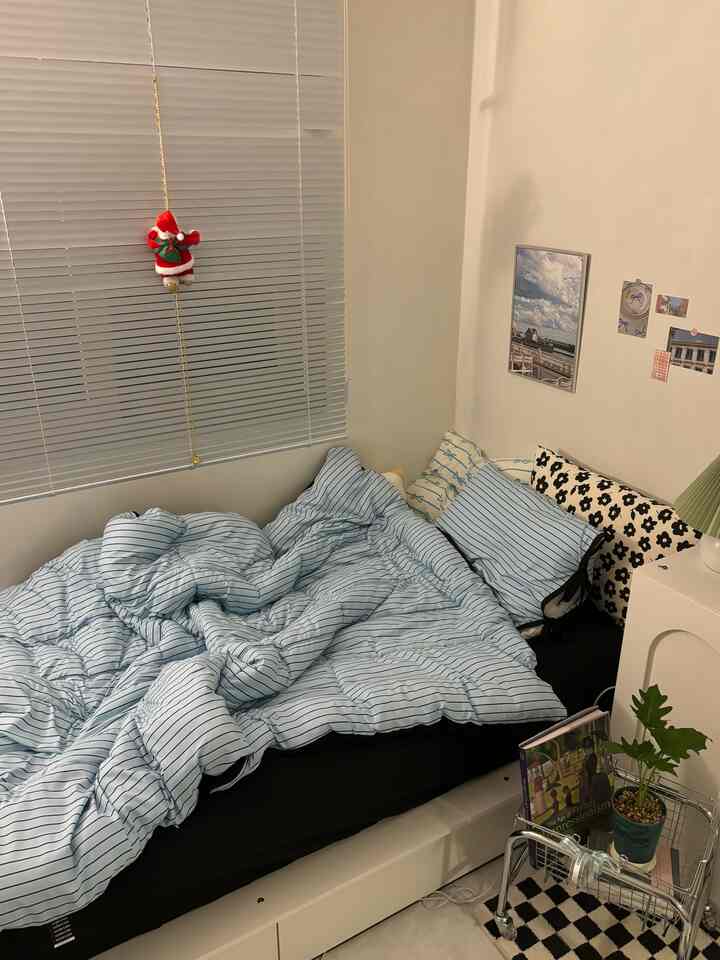 Simple bedroom with white walls and blue striped bedding in a compact 4.5-tatami sized room