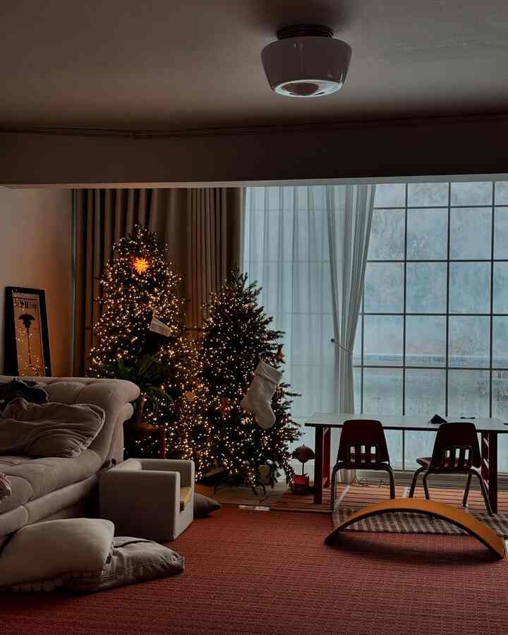 白と茶色のリビングルーム、クリスマスツリーと子供用テーブルが配置された温かみのあるヴィンテージインテリア