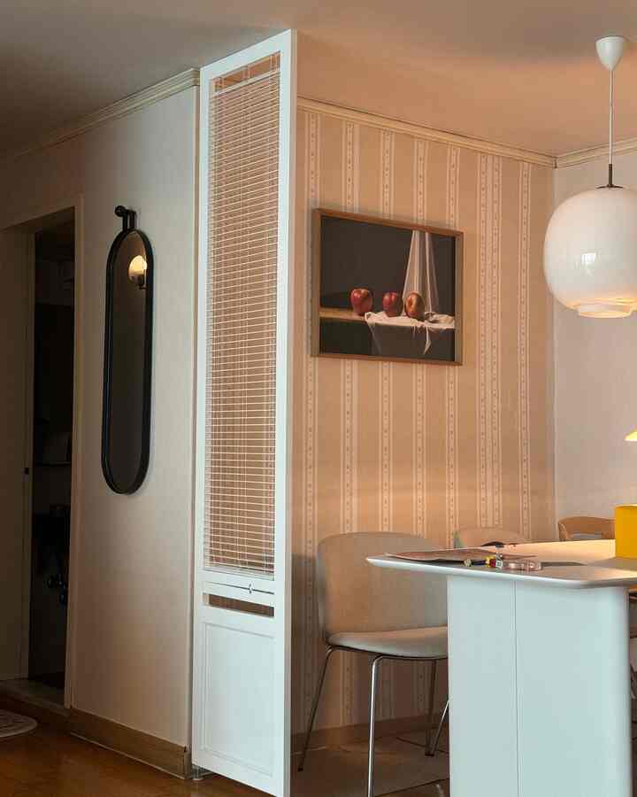 ベージュの壁紙に囲まれた白いテーブルとダイニングチェアが配置された、温かみのあるナチュラルな雰囲気のダイニングルーム