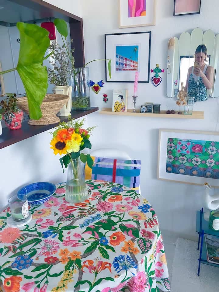 明るく華やかなホワイトトーンのダイニング、花柄のテーブルクロスと多彩な植物が調和した温かみのある空間