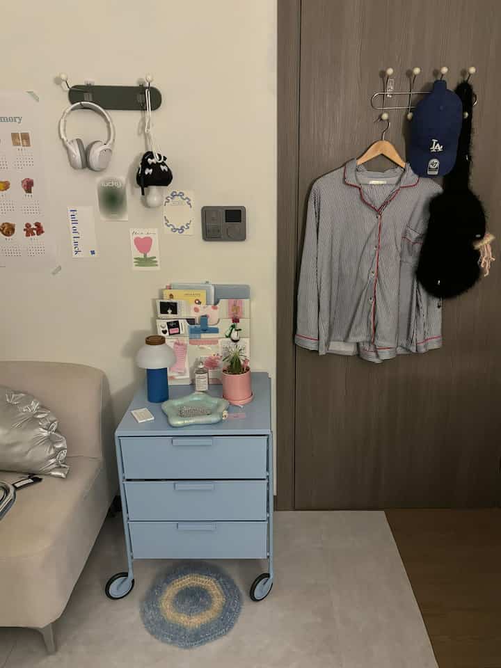 ベージュのソファとペールブルーのキャビネットが配置された子供部屋、収納と整理が際立つすっきりとした空間