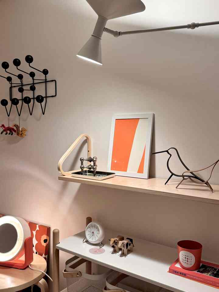 Natural and white toned kids' room featuring shelves and lighting with a clean, minimal atmosphere