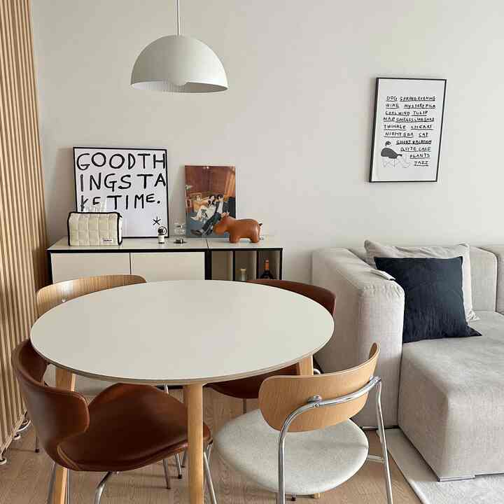 ホワイトとブラウンの色調のリビングダイニングスペース、モダンな家具とキャビネットが配置された雰囲気のあるインテリア