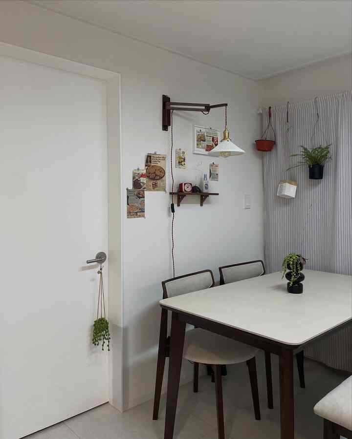 クリームベージュ天板の木製ダイニングテーブルとダークブラウンの木製椅子が配置された白色のキッチンスペース