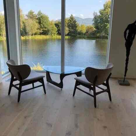 My own little oasis to relax while soaking in the stunning lake view right outside my home! 🌊✨ There's nothing like this peaceful spot to unwind and recharge. #LakeLife #HomeSweetHome #MidCenturyModern #GlassCoffeeTable #ScandinavianDesign #Hermanmillercoffeetable