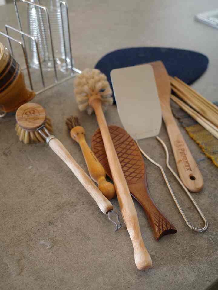 Natural beige-toned kitchen utensils arranged neatly on a clean kitchen countertop with an organized atmosphere