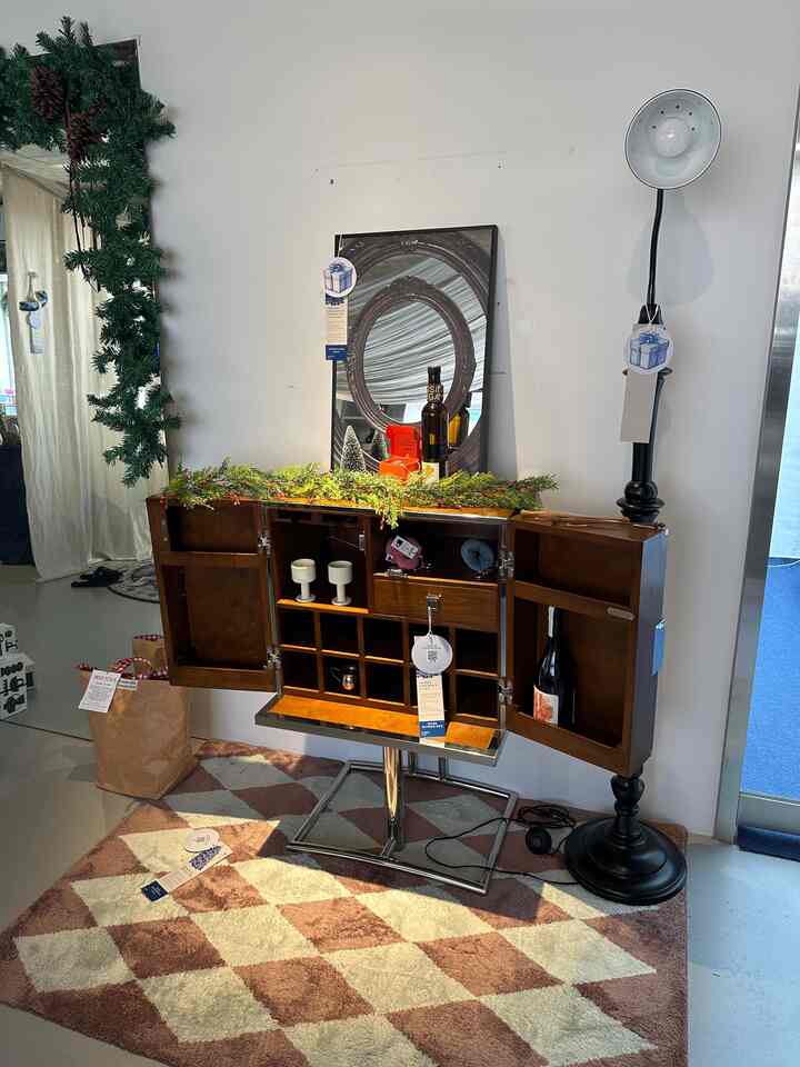 ブラウンの木目調収納キャビネットと黒いフロアランプが配置された、シンプルで清潔感のあるインテリア空間