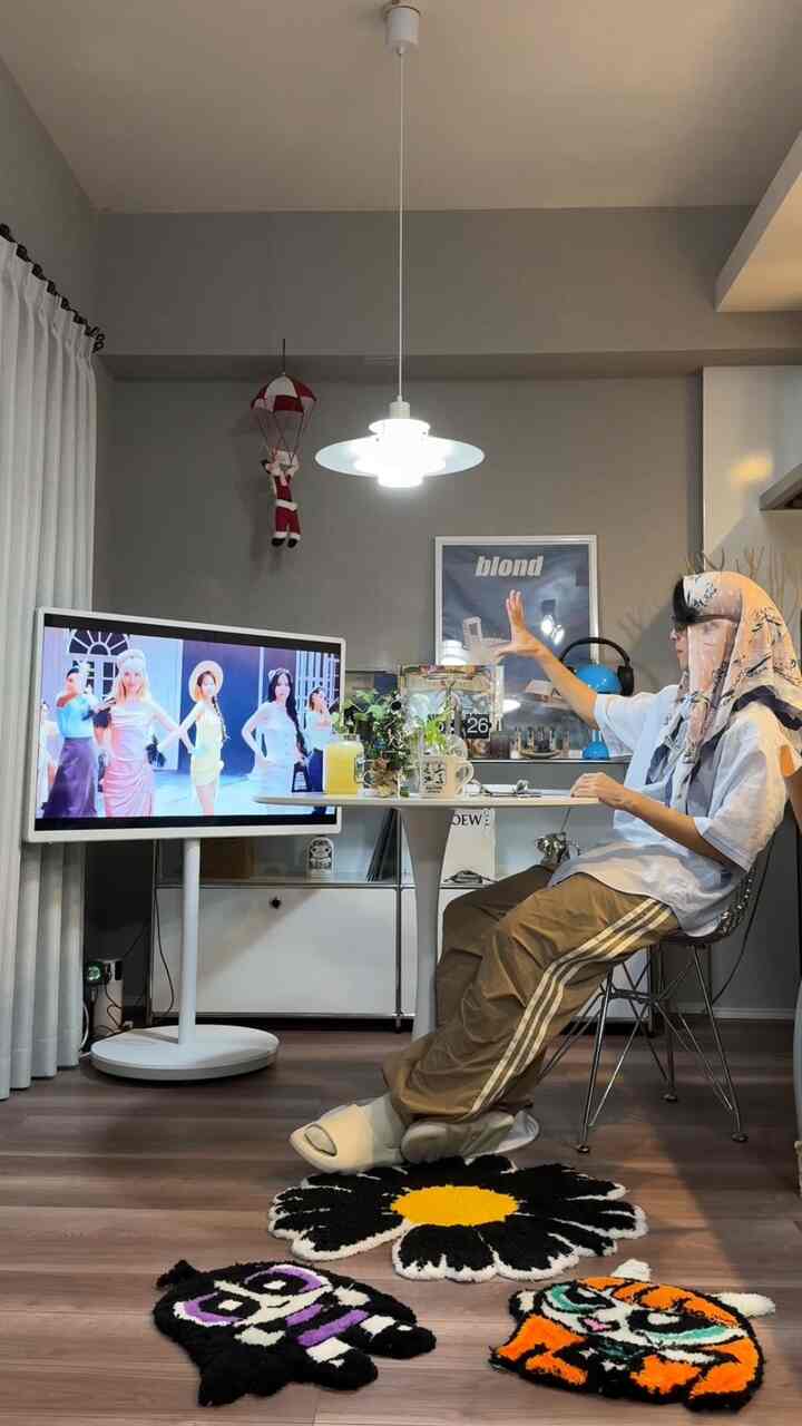 明るくモダンなリビング、白いラックと円形のカフェ風テーブルに植物とティーカップが配置された雰囲気のあるインテリア