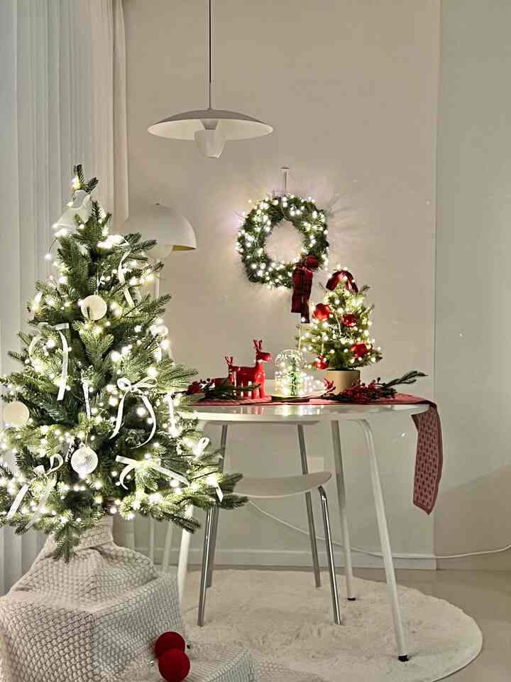 白と緑の色調のリビング、クリスマスツリーと飾りが配置された雰囲気のあるインテリア