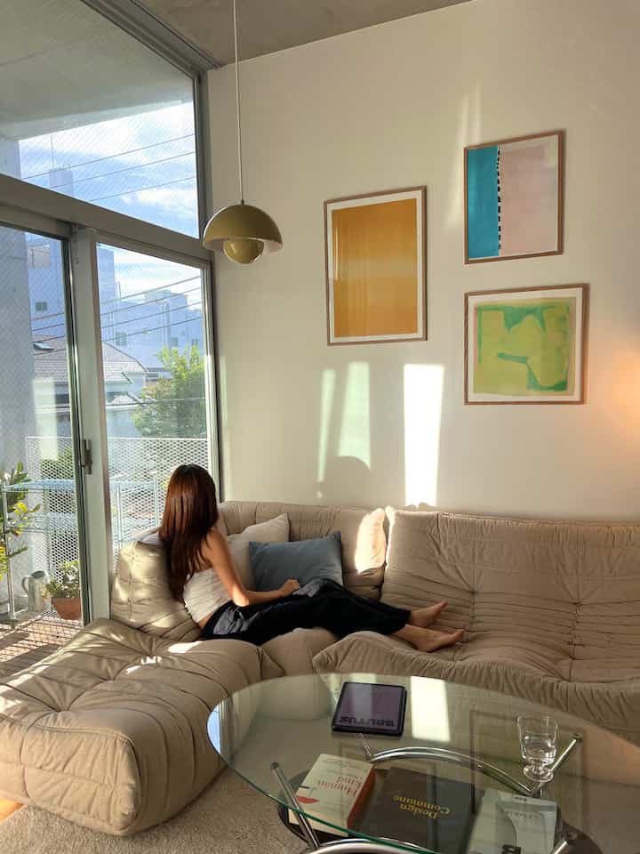 Beige-toned living room featuring a beige sectional sofa and glass coffee table with a natural ambiance