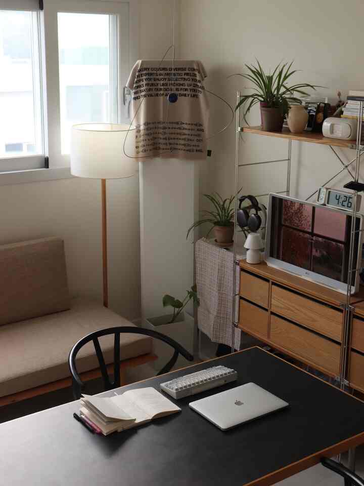 ナチュラルカラーでモダンな7坪のリビング兼書斎、デスクとソファが配置された落ち着いた空間