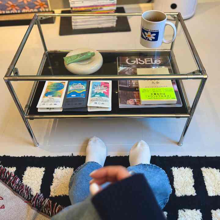 White floor and black coffee table in a simple modern living room for a single household, with a cozy home cafe atmosphere
