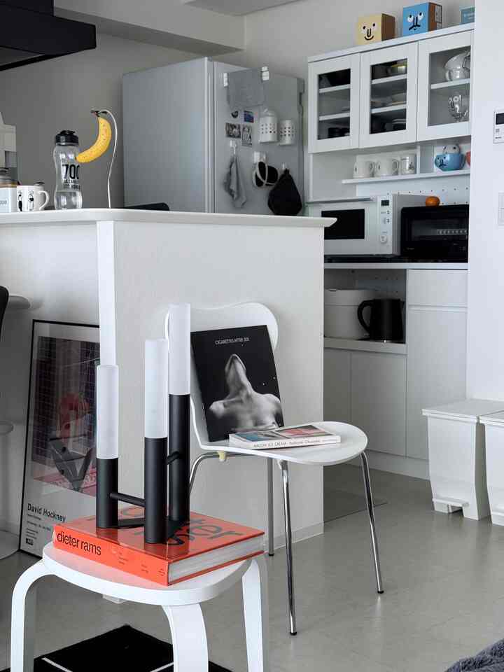 White-tone kitchen featuring modern furniture, stool, and dining chair arranged in a clean and bright space