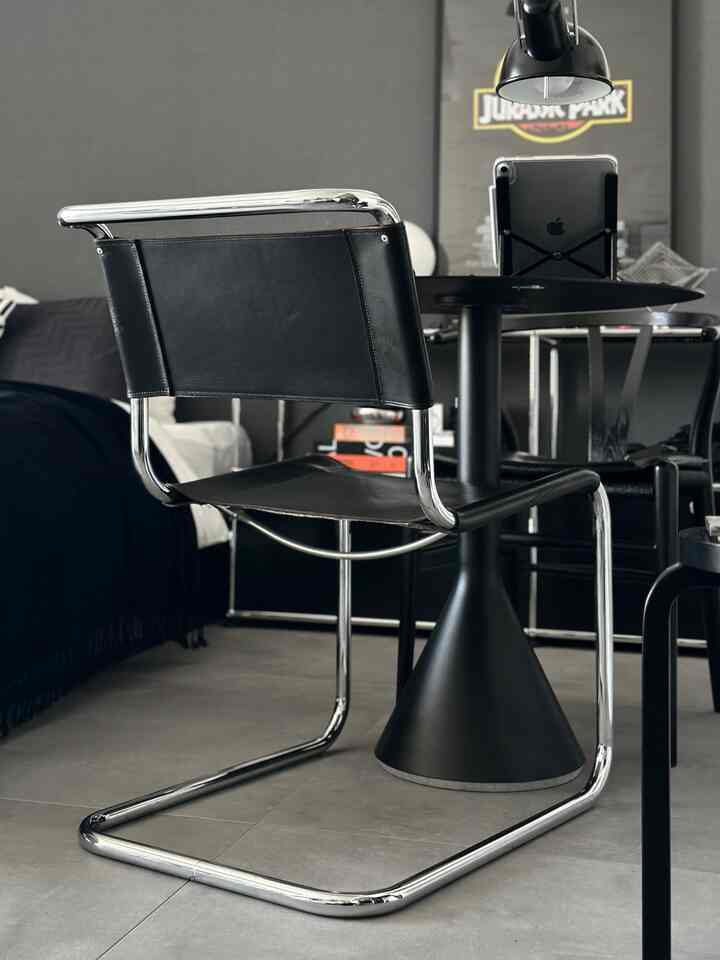 Modern black and metal tone living room featuring a stool and table with sleek, stylish atmosphere