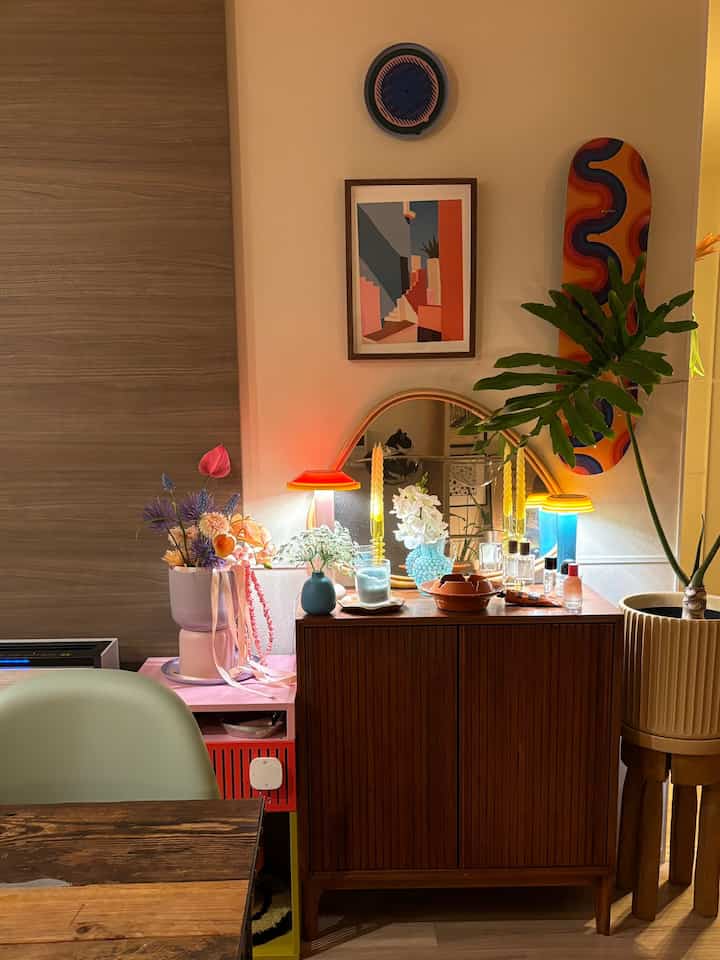 温かみのあるブラウン調のナチュラルなリビング、ミッドセンチュリーモダン家具と花瓶、間接照明が配置された印象的な空間