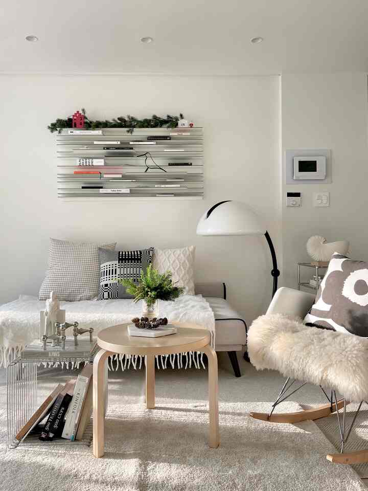 ホワイトと木目調のナチュラルモダンなリビング、シンプルなソファとラウンドテーブル、フロアランプが配置された印象的な空間