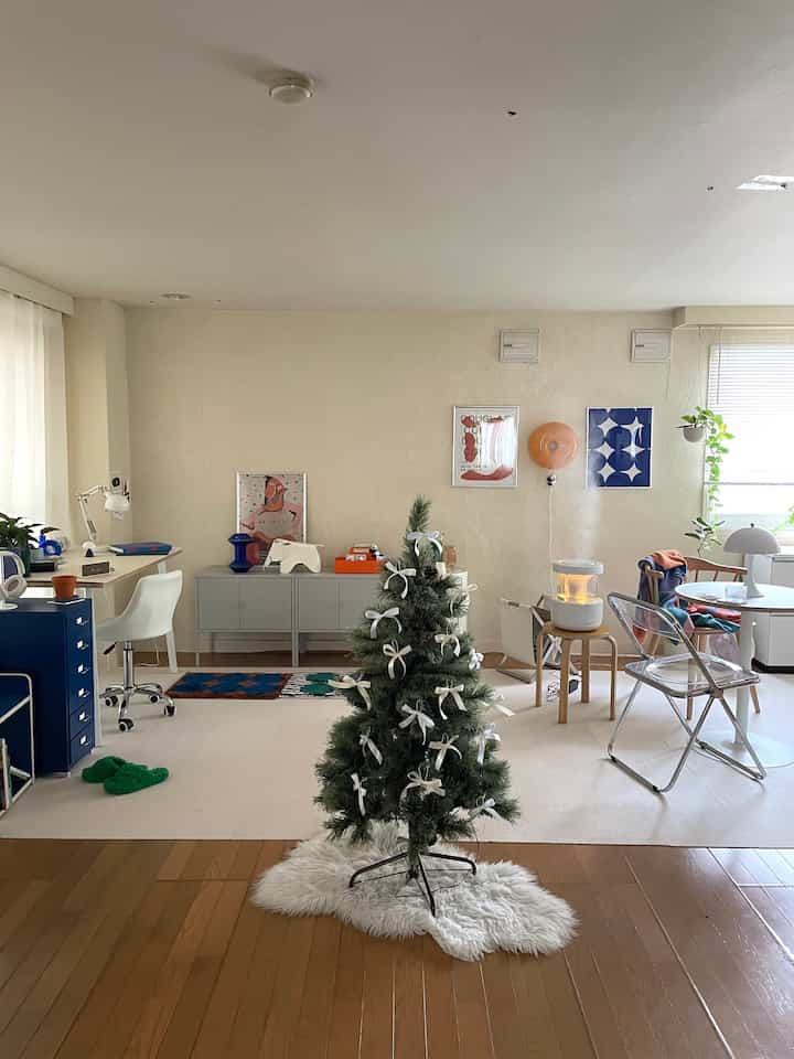 Light brown and white tone 1DK space featuring a decorated Christmas tree and practical furniture with a cozy atmosphere
