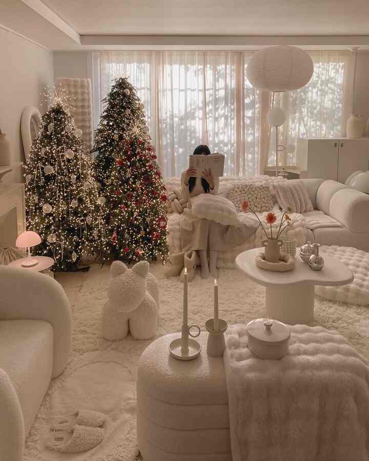 アイボリートーンのリビングルーム、ふわふわのソファとクッション、クリスマスツリーが温かみのある雰囲気を演出する空間