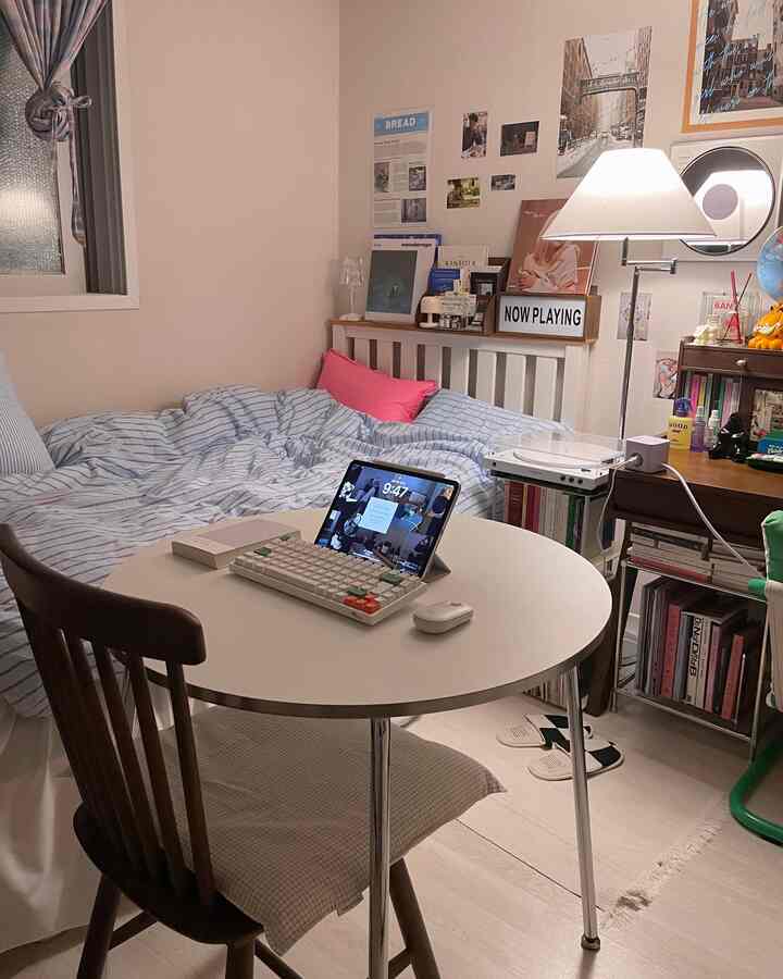 ホワイトとブラウンの調和したワンルームの寝室、デスクとフロアランプが配置された雰囲気のあるインテリア