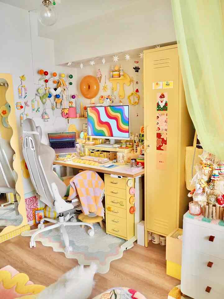 Pastel-toned compact home office featuring a yellow drawer unit and colorful wall decor creating a cozy workspace