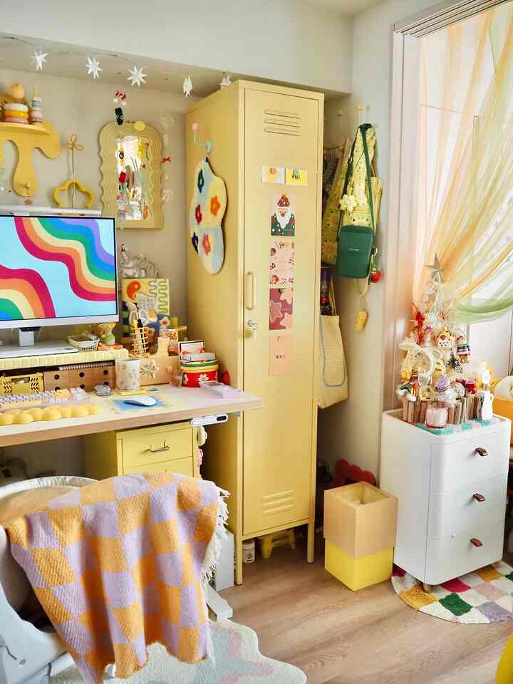 黄色のトーンが特徴的な狭い部屋、デスクと鮮やかな黄色キャビネットが配置された印象的な北欧風インテリア
