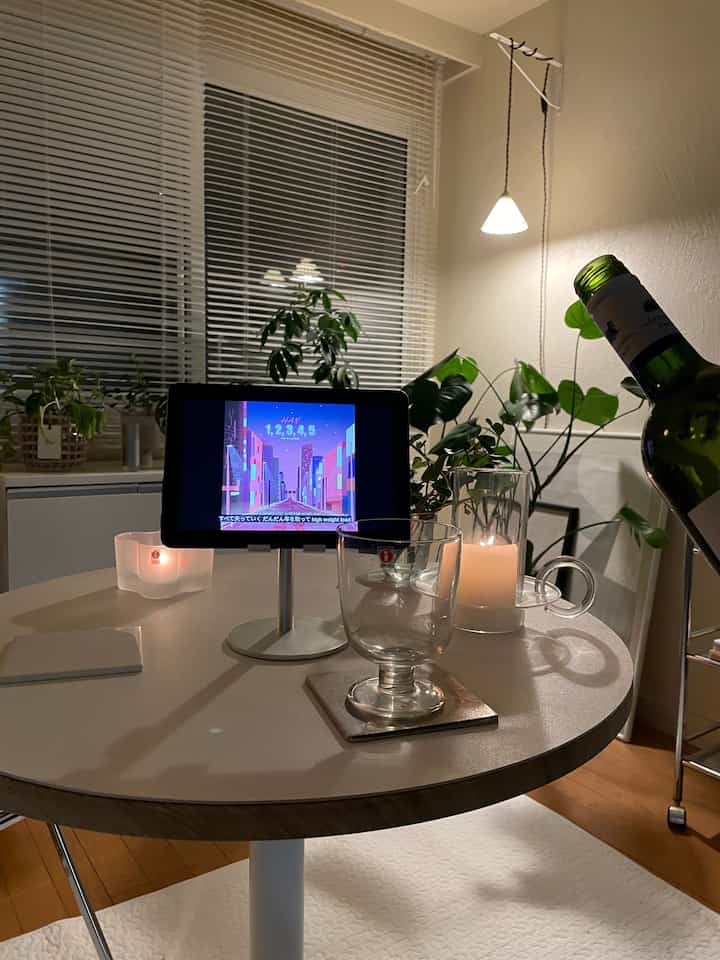 白とベージュ調の丸テーブルにグラスとキャンドルが置かれた、1DK韓国インテリアの雰囲気ある夜の空間