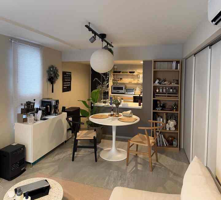 White walls and wood-toned furniture in a 2LDK apartment for two, featuring Japandi style and pendant light in cozy living-dining area