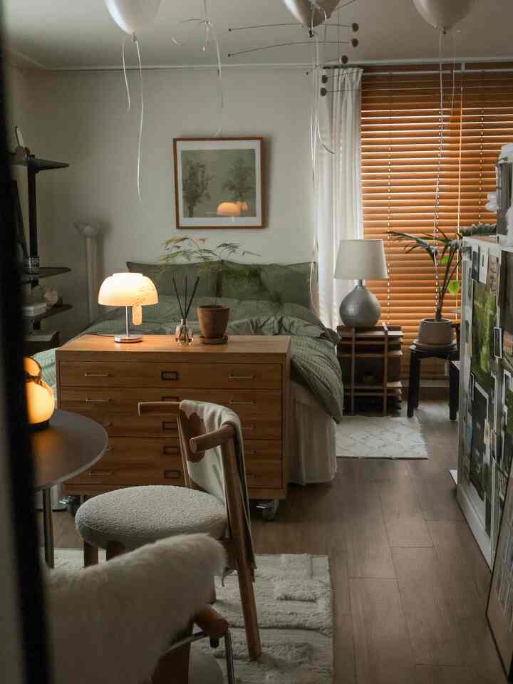 ナチュラルな木目調とグリーンの色彩が広がる8坪のワンルーム、クローゼットを間仕切りに使った落ち着いた寝室インテリア