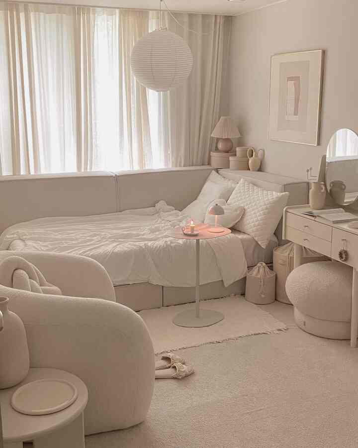 暖かいベージュ調のリビング、ベージュのソファとアームチェア、化粧台が調和するシンプルな空間