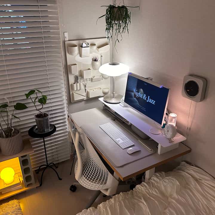 白とベージュのトーンが特徴的なワンルームのホームオフィス、ハーマンミラーの椅子と整然としたデスクが配置されたシンプルモダンなインテリア