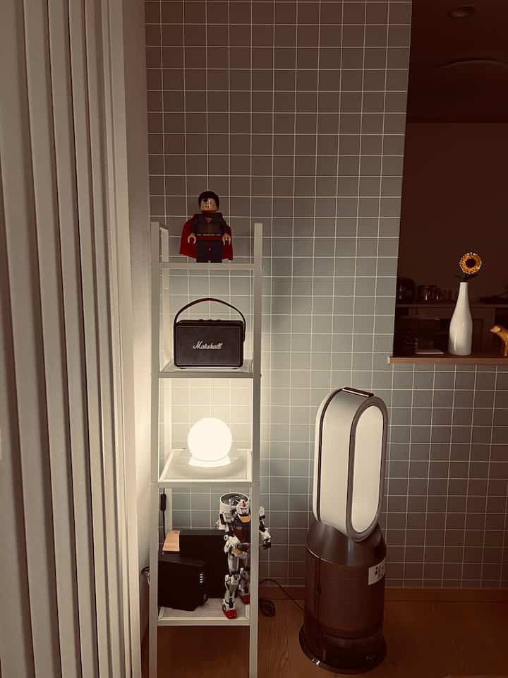 白と木目調が調和したコーナー収納の棚と空気清浄機が置かれた清潔感のある空間