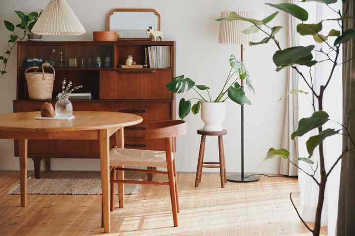 Natural vintage dining room with white walls and wood tone furniture arranged