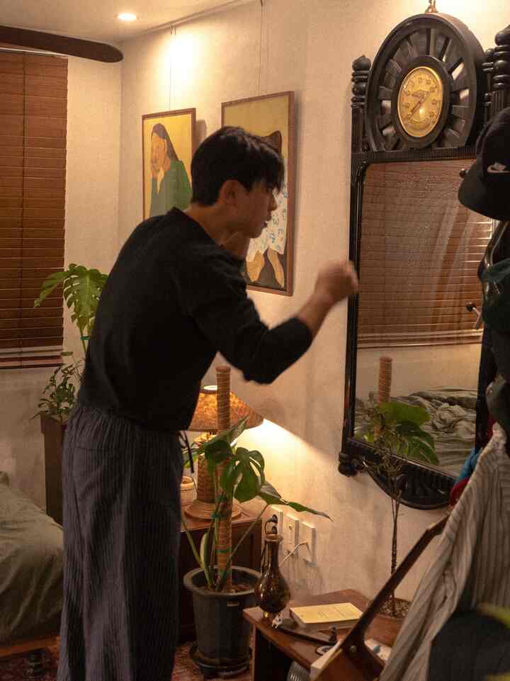 ナチュラルな色調の落ち着いた寝室、大きな鏡と観葉植物が配置された雰囲気のあるインテリア