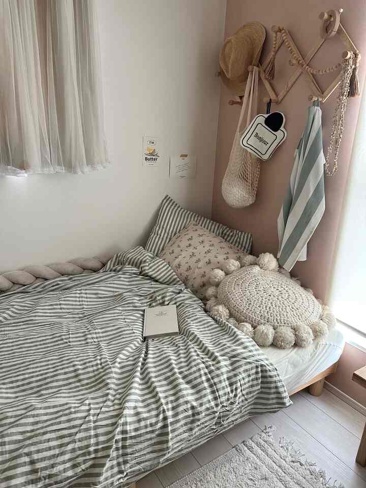Natural toned 6-tatami bedroom featuring a cozy bed with cushions and blanket, accented by wall decorations creating a warm atmosphere