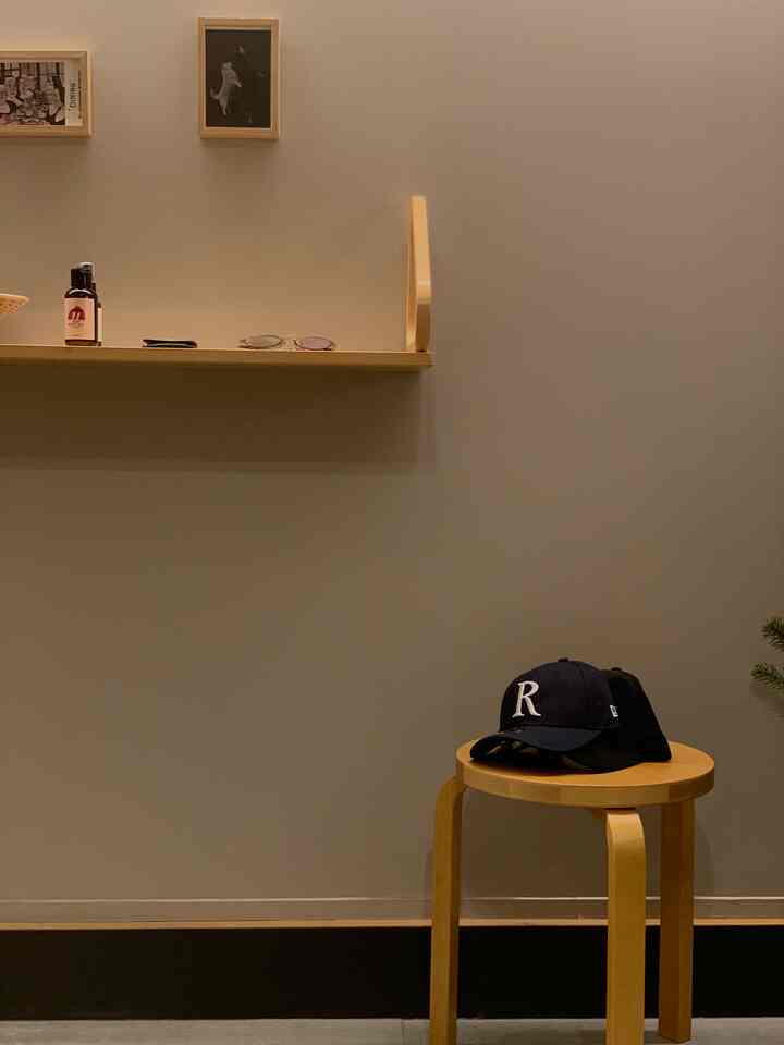 Natural brown-tone entrance space featuring an Artek stool and wall shelf in a clean, simple Nordic style interior