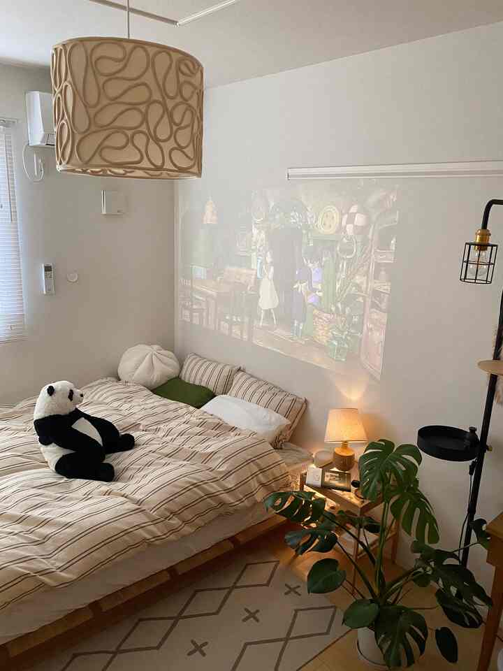 Nordic-style bedroom with white walls and light brown bed frame, cozy bedding, and plants creating a calming atmosphere