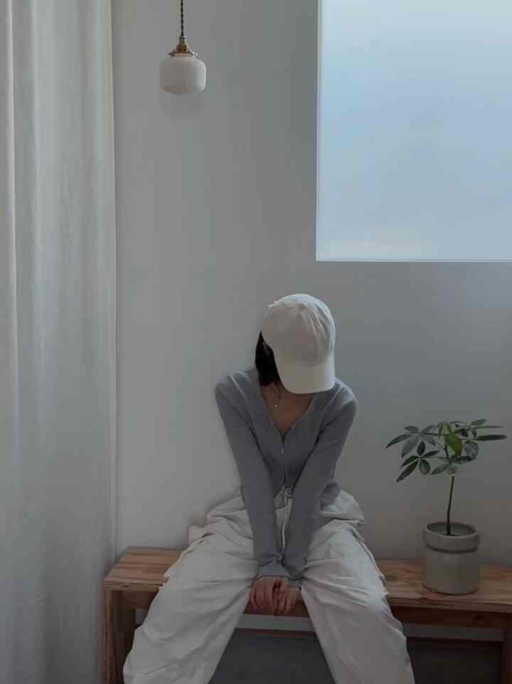 白と木目調の玄関、シンプルなベンチとペンダントライトが配置された落ち着いた雰囲気のインテリア