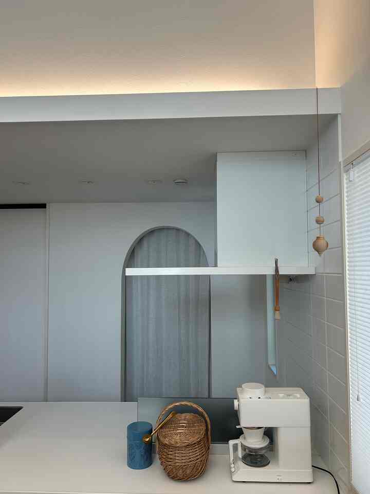 白と茶色を基調としたキッチン空間に、全自動コーヒーメーカーとかごが配置され、清潔で落ち着いたおうちカフェの雰囲気