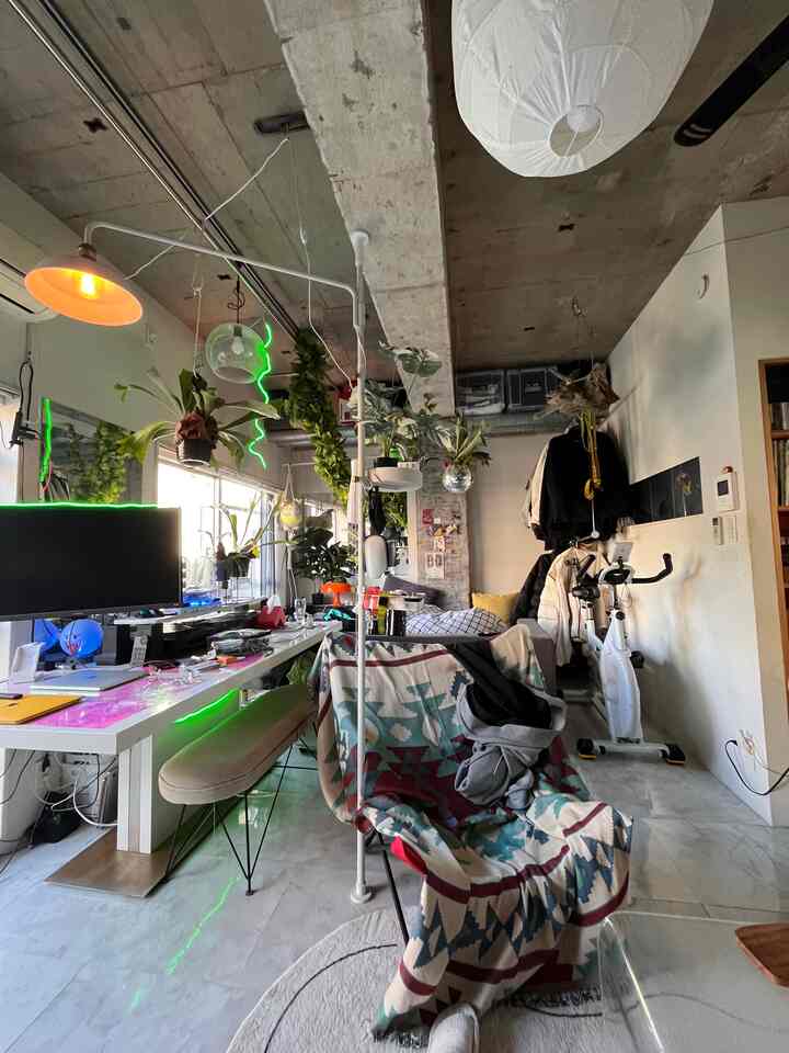 Natural-toned studio apartment home office featuring pendant lights and plants creating a cozy workspace