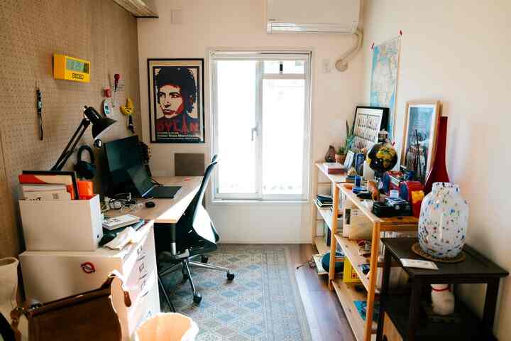 明るいベージュと木目調の調和が取れたコンパクトなワークスペース、デスクとオフィスチェア、収納棚が配置された清潔感のある空間